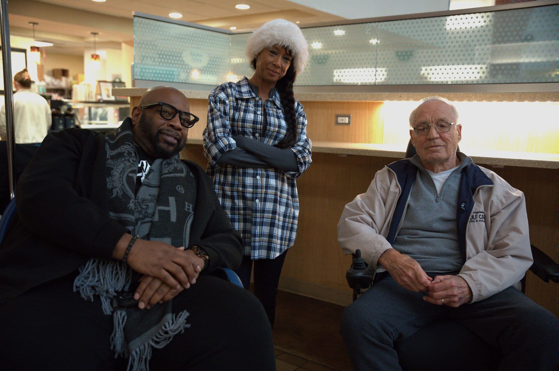 Three people seated together in a care facility lounge